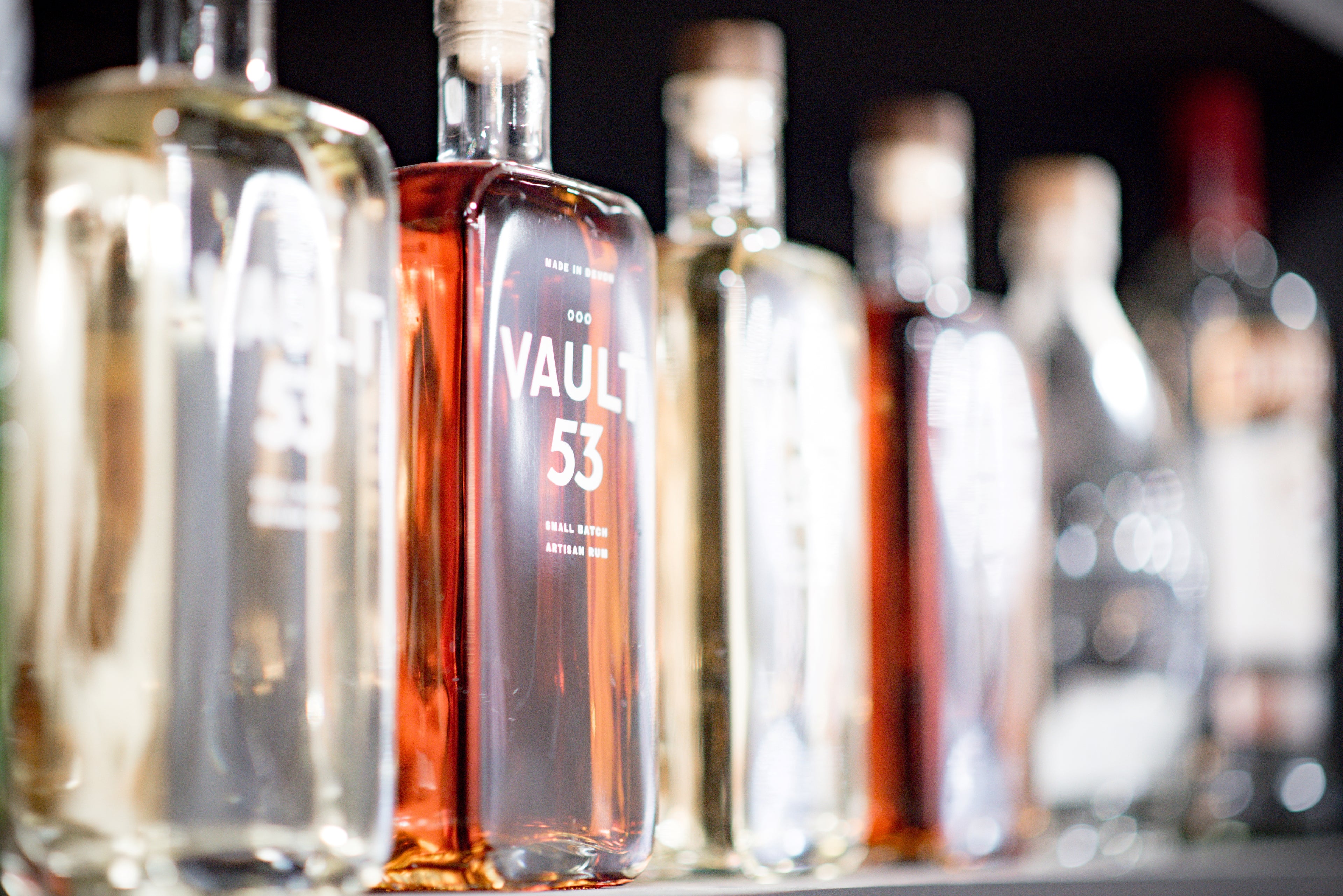 Bottles of 'VAULT 53' on a bar with blurred background